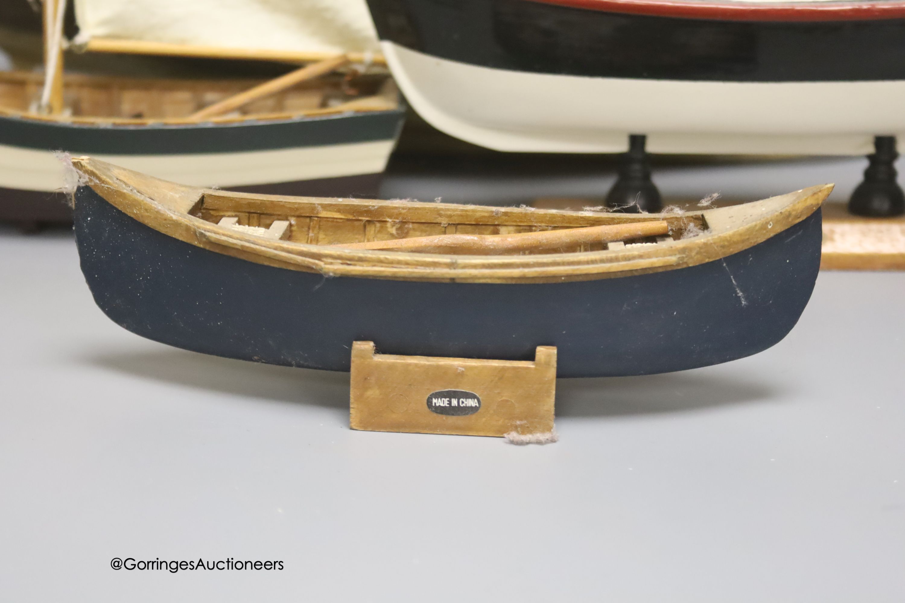 A clinker-built wood rowing boat, 41cm, and four smaller boat models